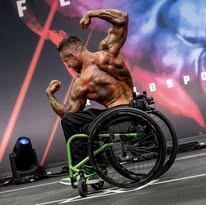 Wheelchair bodybuilding competitor hitting a back pose on stage