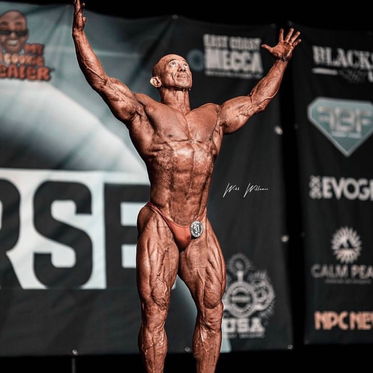 Bodybuilding athlete presenting a conditioned physique on a competition stage under the lights