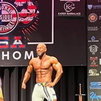 Men's physique competitor posing on the USA Championships stage in Oklahoma