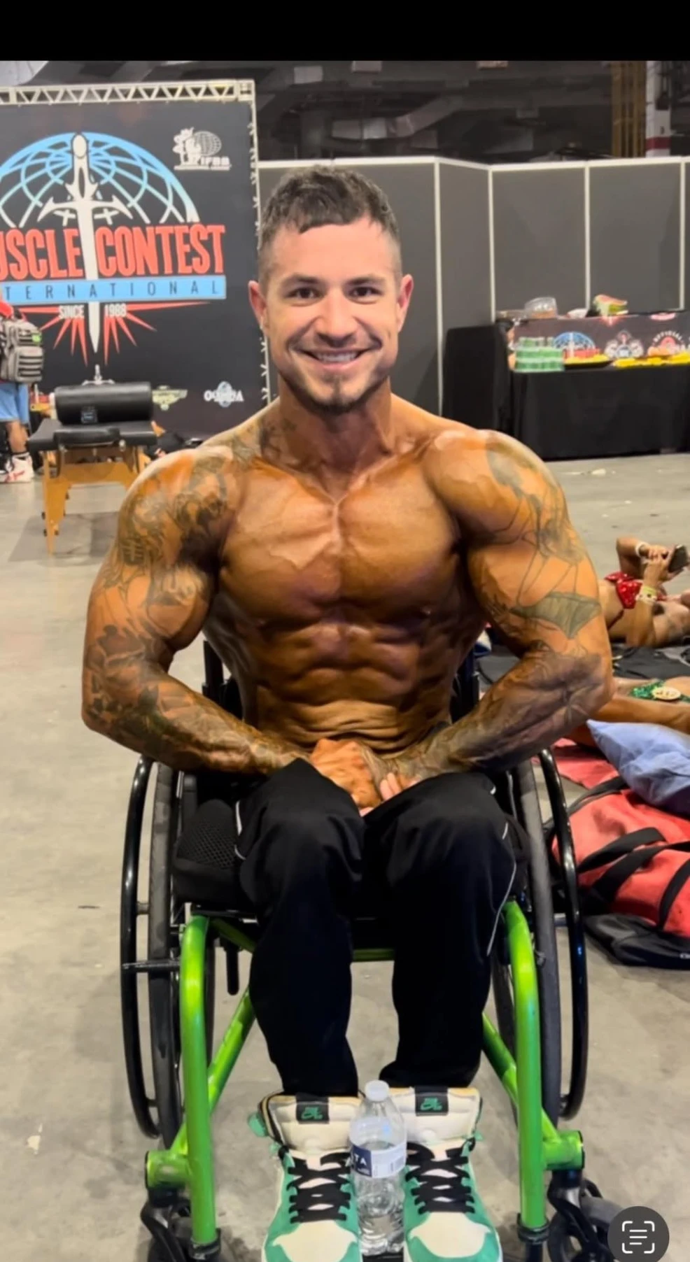 Brink Physiques wheelchair competitor backstage in contest condition at an IFBB Muscle Contest International event