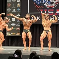 Competitors side by side in a stage lineup at an NPC Oklahoma show