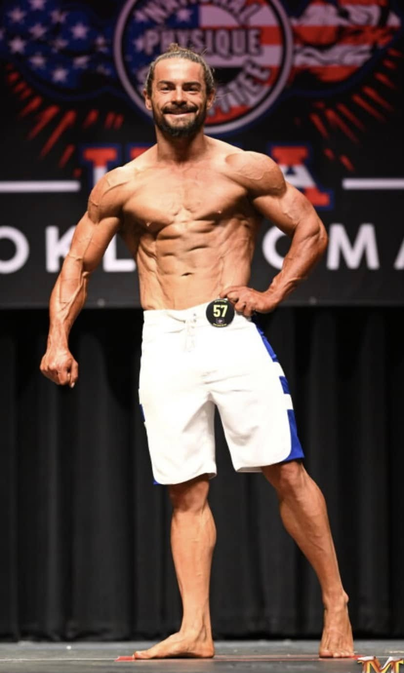 Men's physique competitor presenting alone on the NPC Oklahoma stage